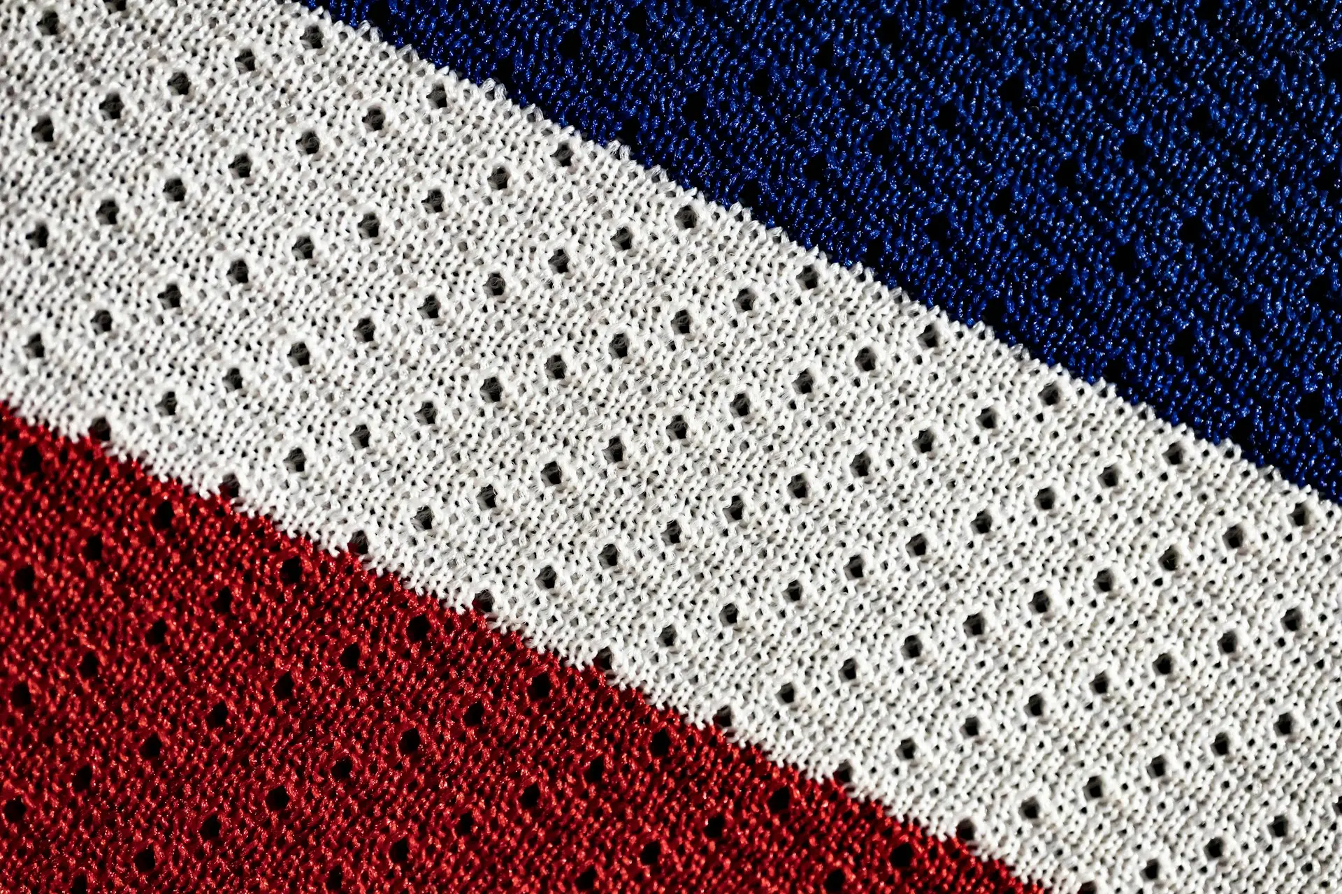 a close up of a red white and blue knitted blanket